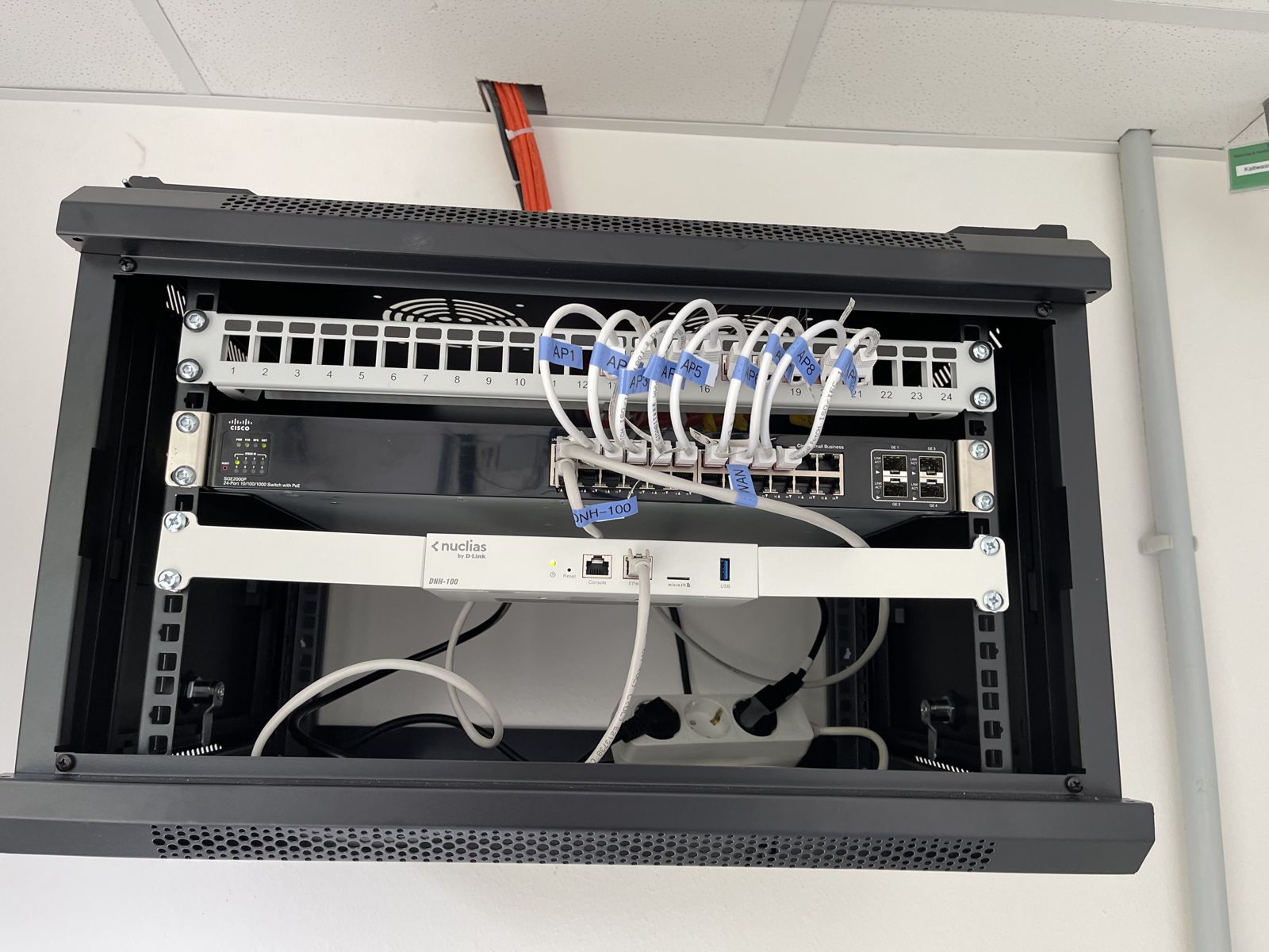 Aufgeräumter Netzwerkschrank mit beschrifteten Patchkabeln und Cloud-Controller